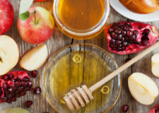 Rosh Hashana, Jewish New Year Holiday, Honey, apple, pomegranate, hala on a wooden table